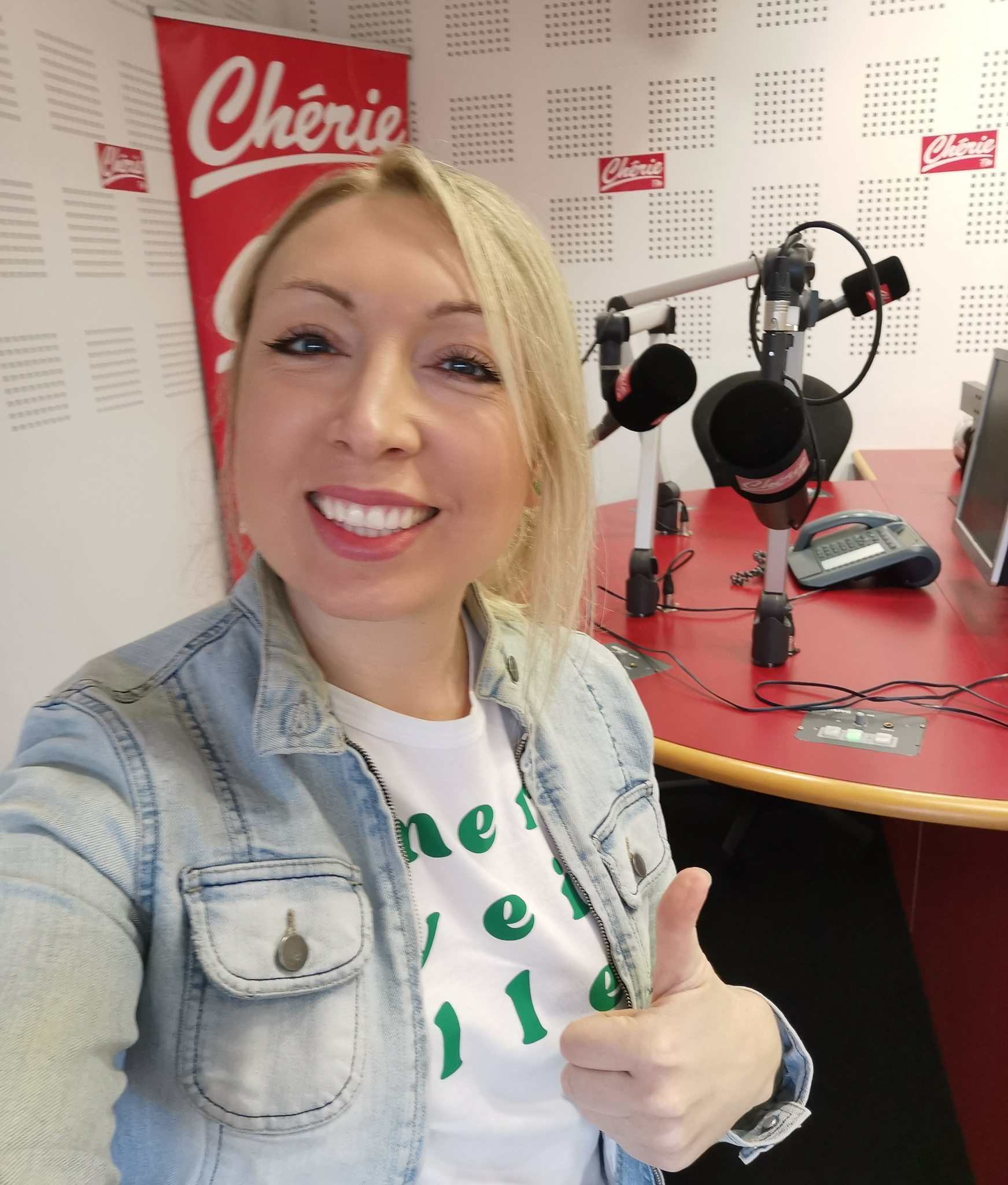 la créatrice de Ouais et alors sourit devant le plateau radio de Chérie FM